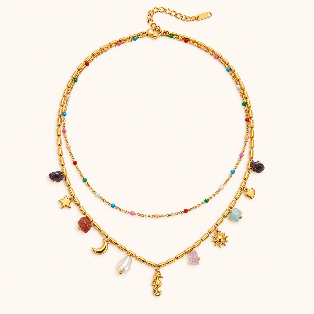 Colorful Coastal Necklace with two gold-tone layers, multicoloured beads and seahorse, celestial and stone charms on an ivory background