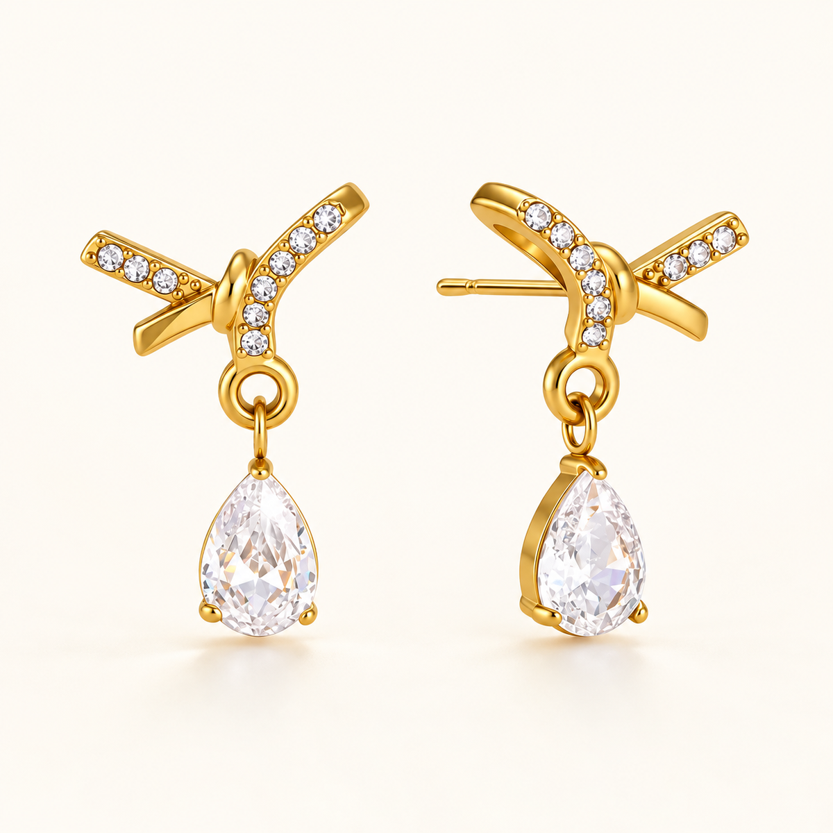 Dewdrop Sparkle Earrings – gold crossed ribbon studs with pear-cut crystal drops