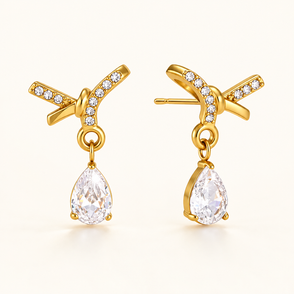 Dewdrop Sparkle Earrings – gold crossed ribbon studs with pear-cut crystal drops