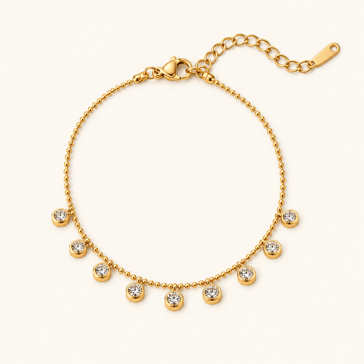 Diamond Whisper Bracelet with a gold-tone ball chain and nine dangling clear stones on an ivory background