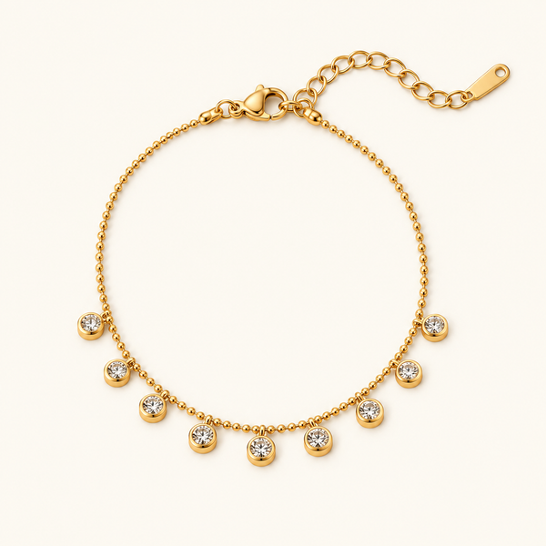 Diamond Whisper Bracelet with a gold-tone ball chain and nine dangling clear stones on an ivory background