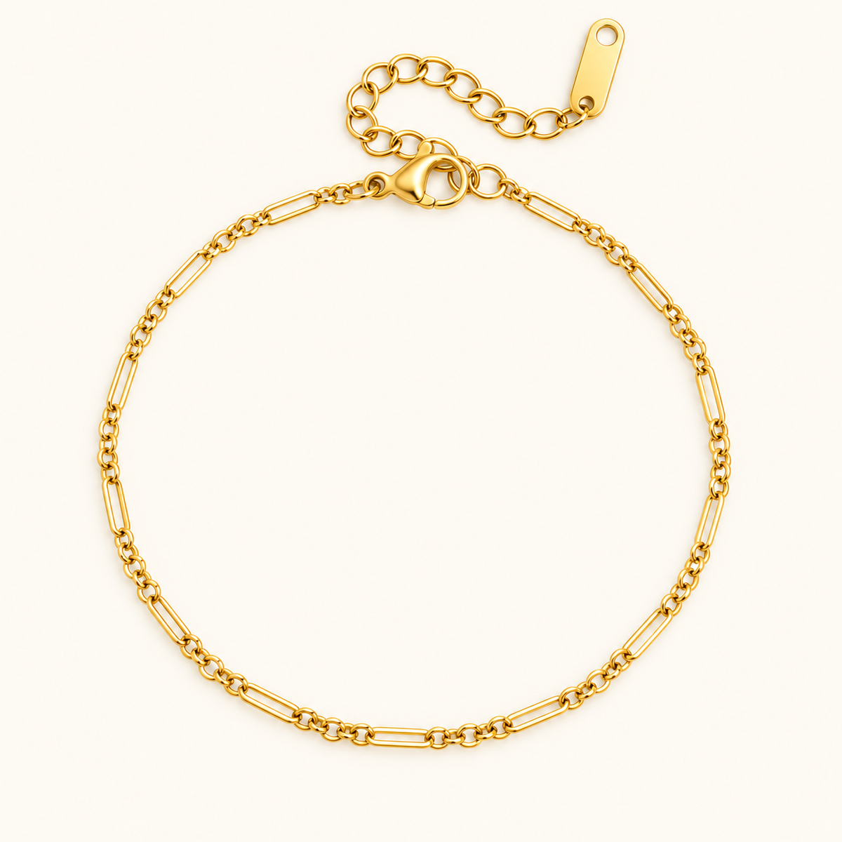 Mixed link bracelet with alternating elongated and small gold-tone links on an ivory background