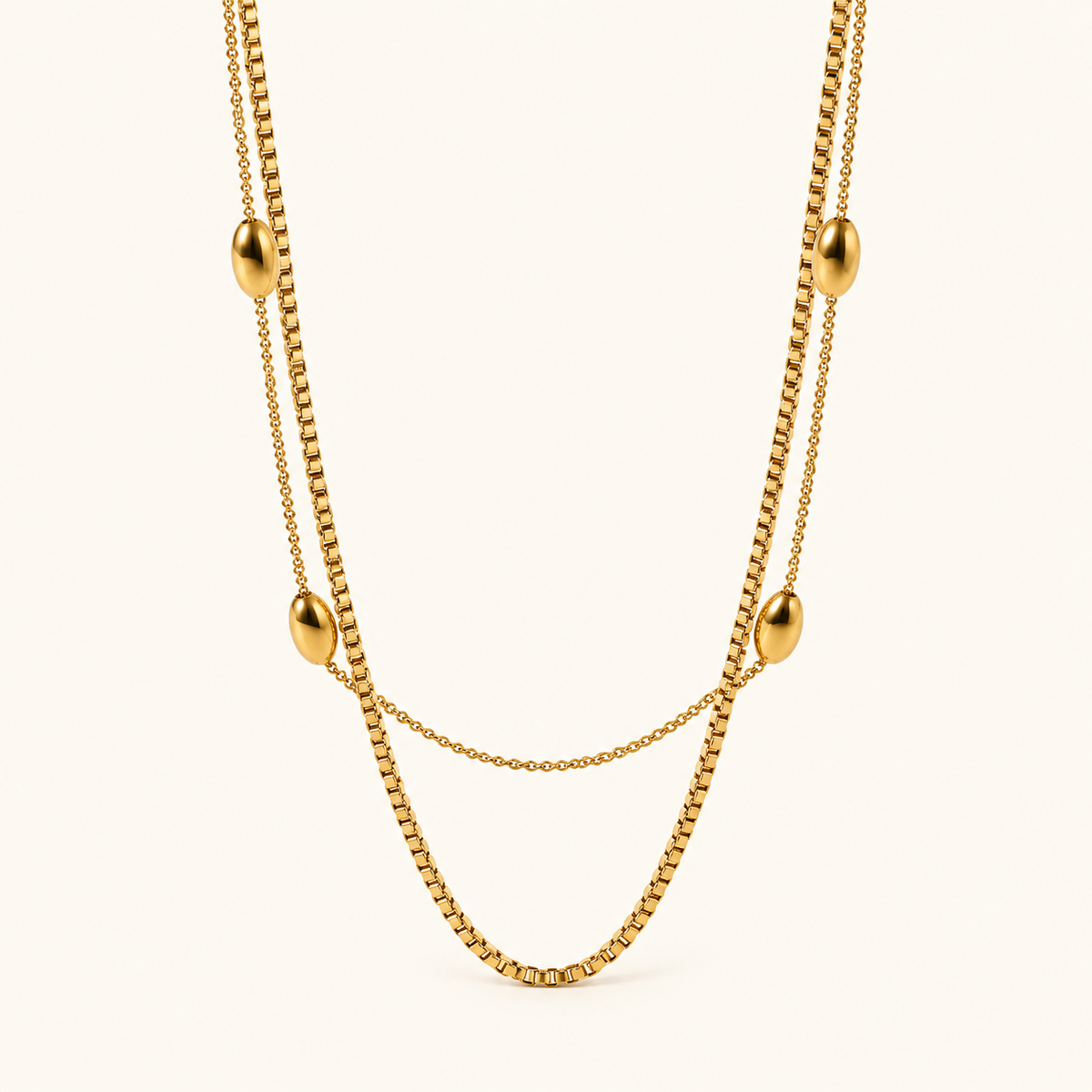 Royal radiance double-layer gold-tone necklace with four oval beads on an ivory background