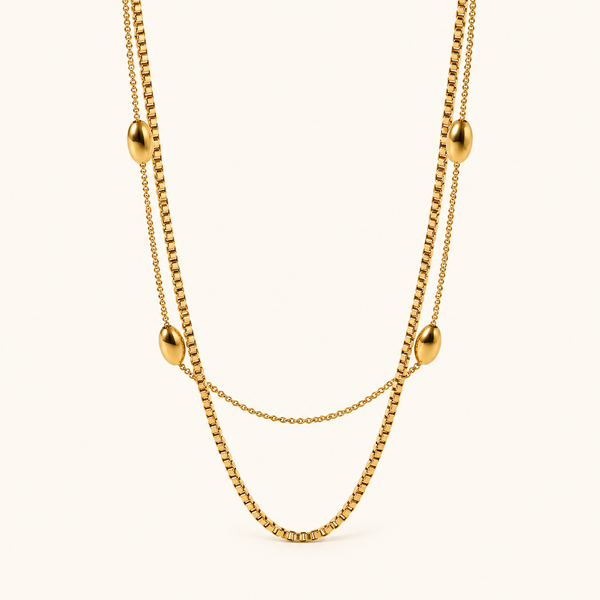 Royal radiance double-layer gold-tone necklace with four oval beads on an ivory background